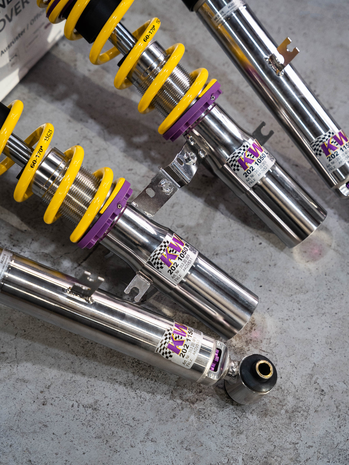 Coilover suspension components laid out in a dark workshop